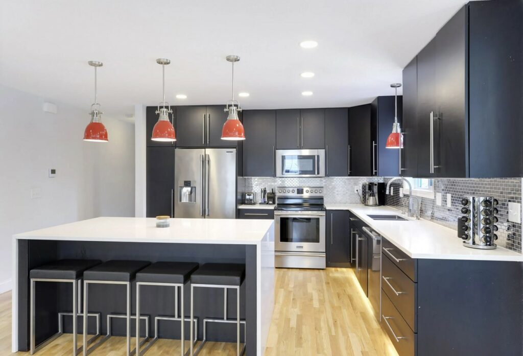 A Sleek Modern Kitchen with Black Cabinets and White Counter Tops